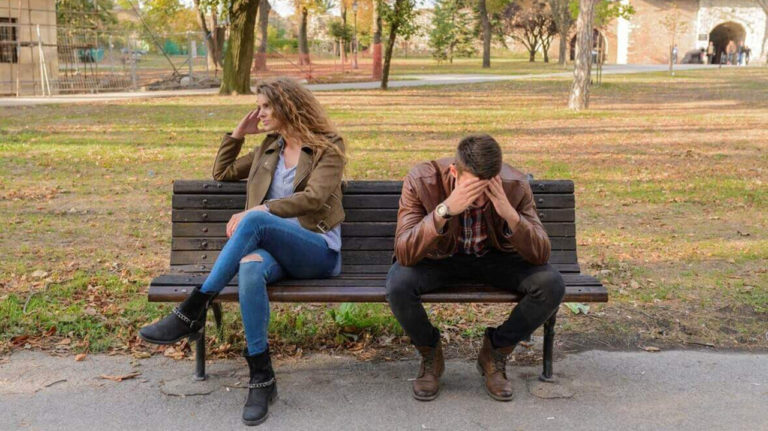 homem e mulher em atrito sentados em banco