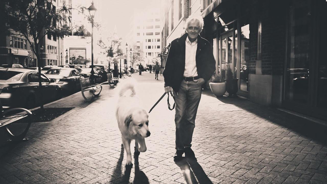 idoso passeia em rua com cachorro à coleira