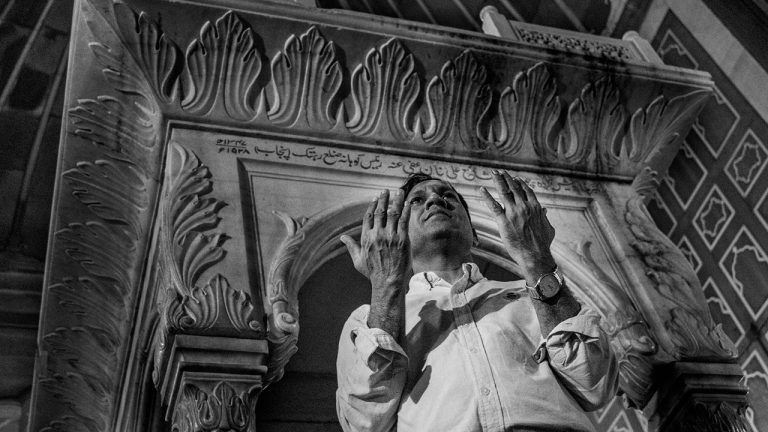 homem rezando em igreja