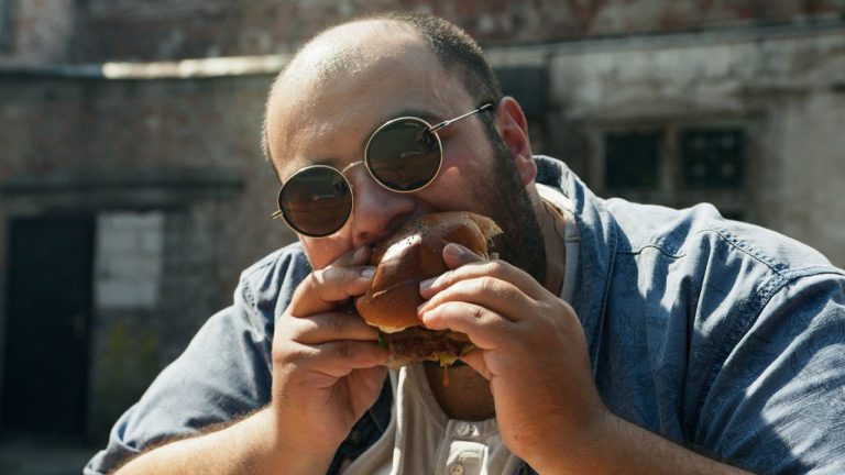 Homem comendo hambúrguer